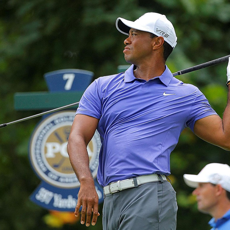 Tiger Woods of the U.S. lets go of his club after his tee shot on the seventh hole during the first round of the 2014 PGA Championship at Valhalla Golf Club in Louisville