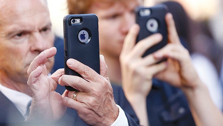 People use iPhones at the film premiere of "Nine Lives" at the TCL Chinese theatre in Hollywood