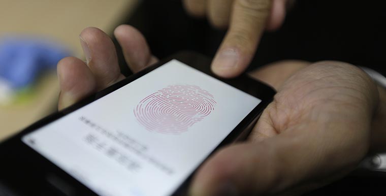 A journalist tests the the new iPhone 5S Touch ID fingerprint recognition feature in Beijing