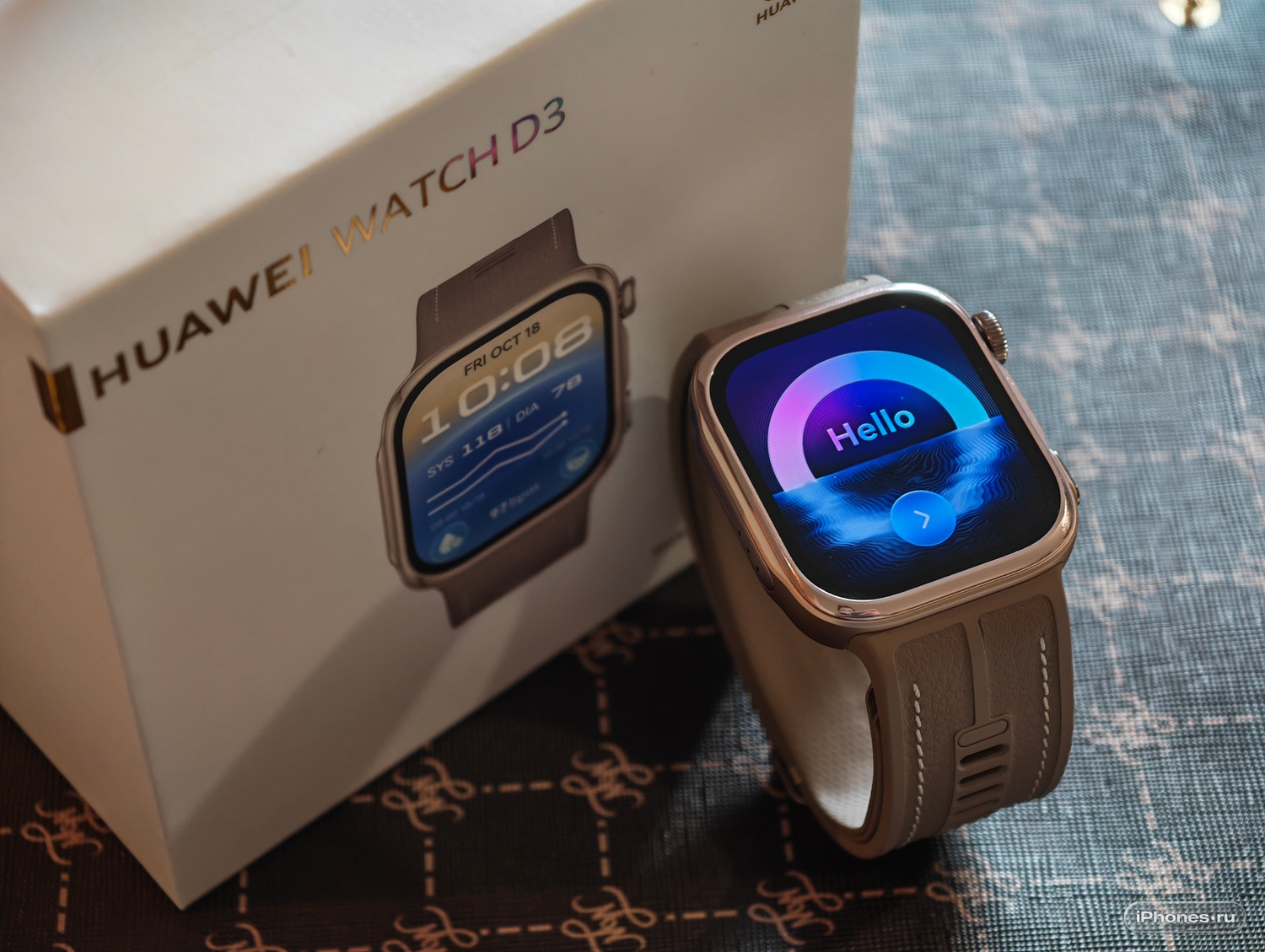 HUAWEI WATCH D3 рядом с коробкой, на экране приветствие Hello